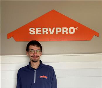 Male employee in front of green SERVPRO vehicle.