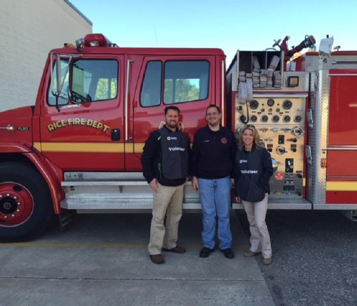Picture of owners in front of a fire truck.